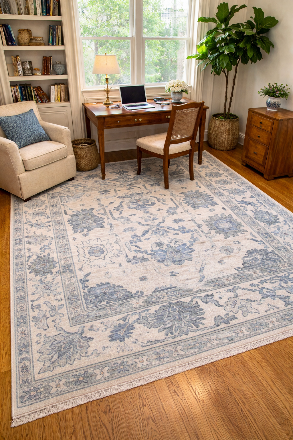 Blue and ivory Oushak rug styled in a bright home office with wooden desk and natural window light, traditional floral area rug on hardwood floor