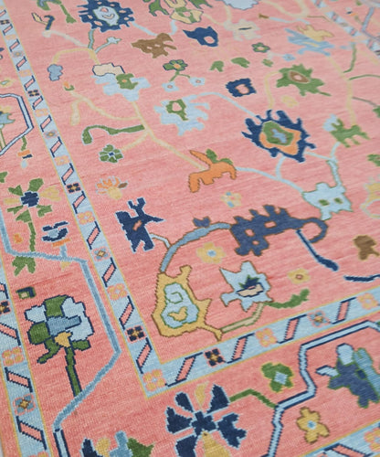 Close up of handwoven wool Oushak rug showing detailed floral and geometric motifs