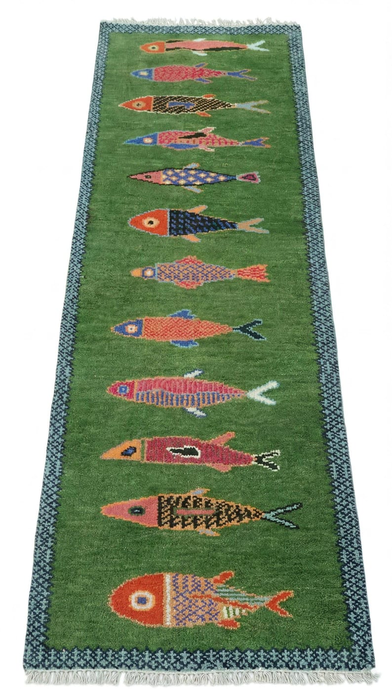 Green runner rug Oushakaura with colorful fish patterns on a white background