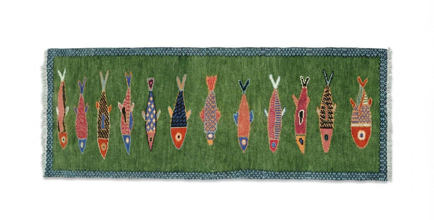 Decorative Oushakaura rug with colorful fish pattern on a green background
