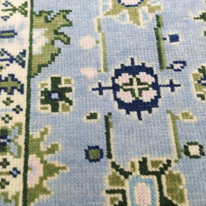 Close-up of a cross-stitched pattern with floral designs on a blue background
