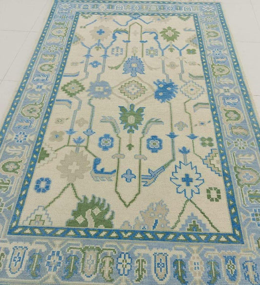 Handcrafted Oushak flatweave rug featuring blue and sage traditional motifs
