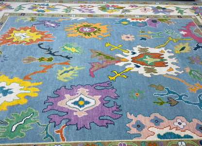 Front view of handcrafted sky blue wool area rug with artistic floral motifs