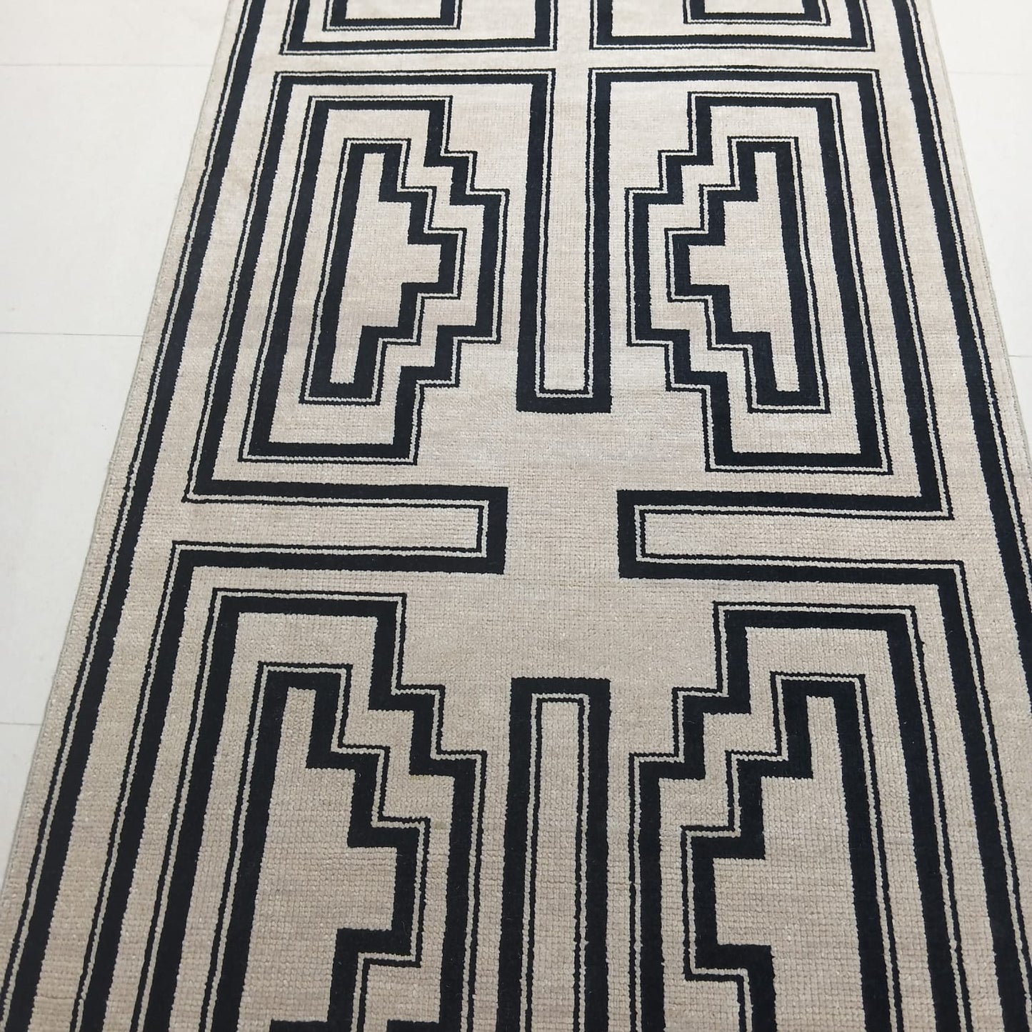 Full view of black and ivory handwoven geometric wool rug
