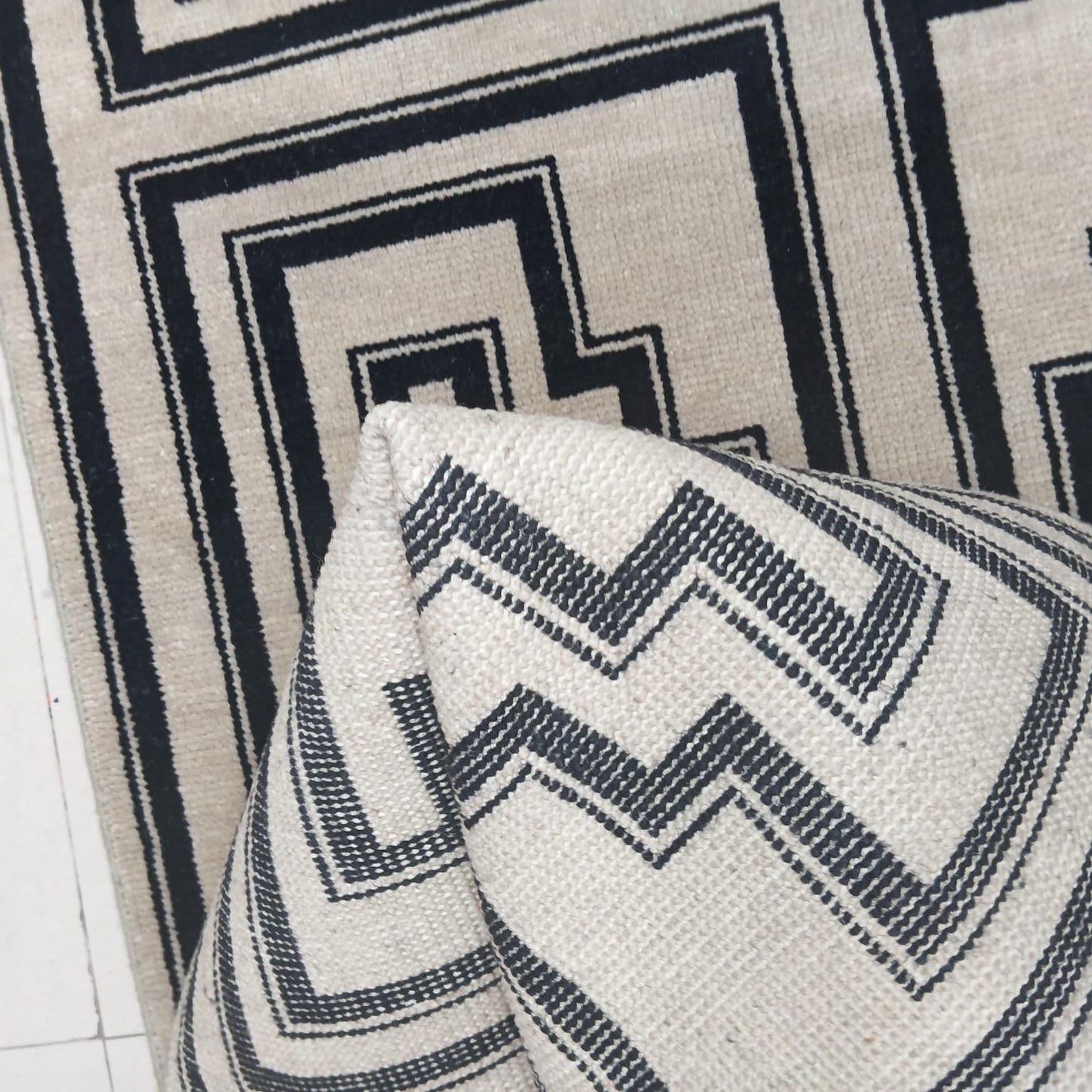 Geometric pattern detail on black and ivory wool rug
