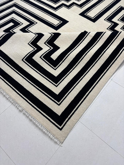 Handwoven edge detail of black and ivory geometric wool rug

