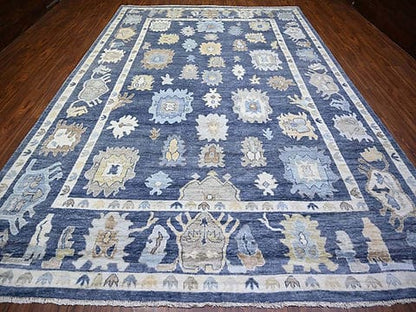 Handmade blue Oushak wool area rug with traditional floral motifs and ivory border.