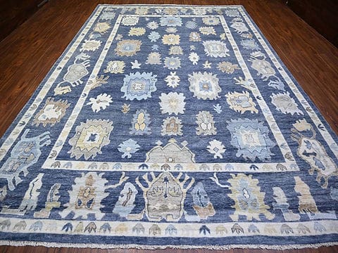 Handmade blue Oushak wool area rug with traditional floral motifs and ivory border.