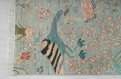 Close-up of blue floral runner rug with bird motif, flowering branches and fringed edge
