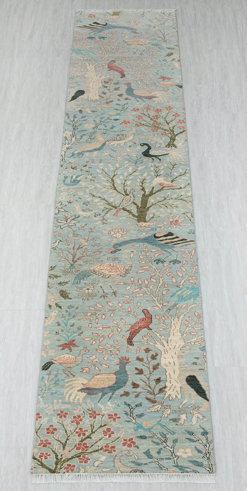 Full view of long blue bird floral runner rug with botanical branches and fringed ends