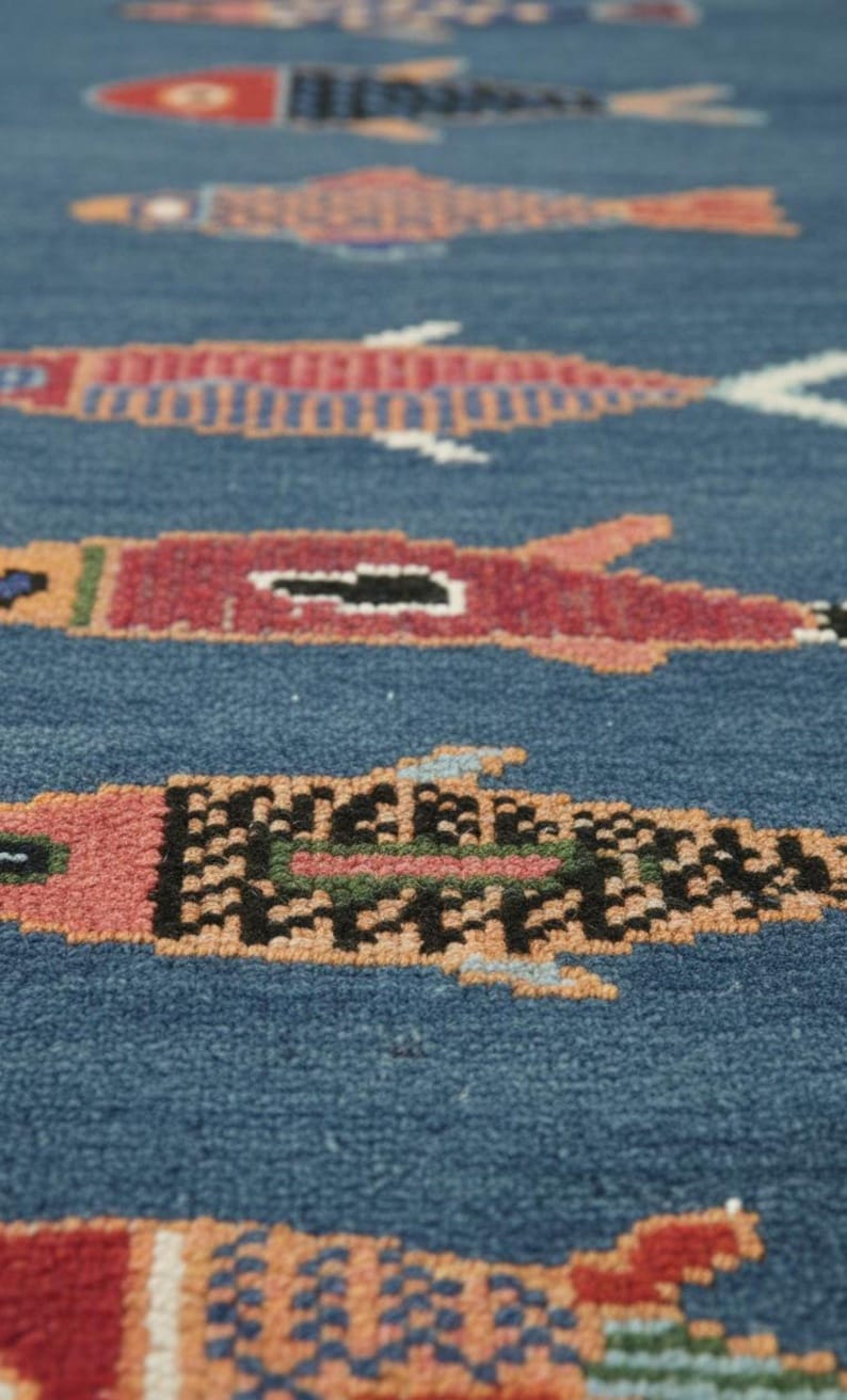 Close-up texture detail of colorful fish pattern handmade blue runner rug