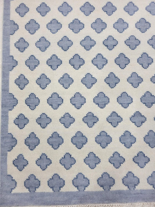 Blue geometric Oushak rug pattern on ivory wool background