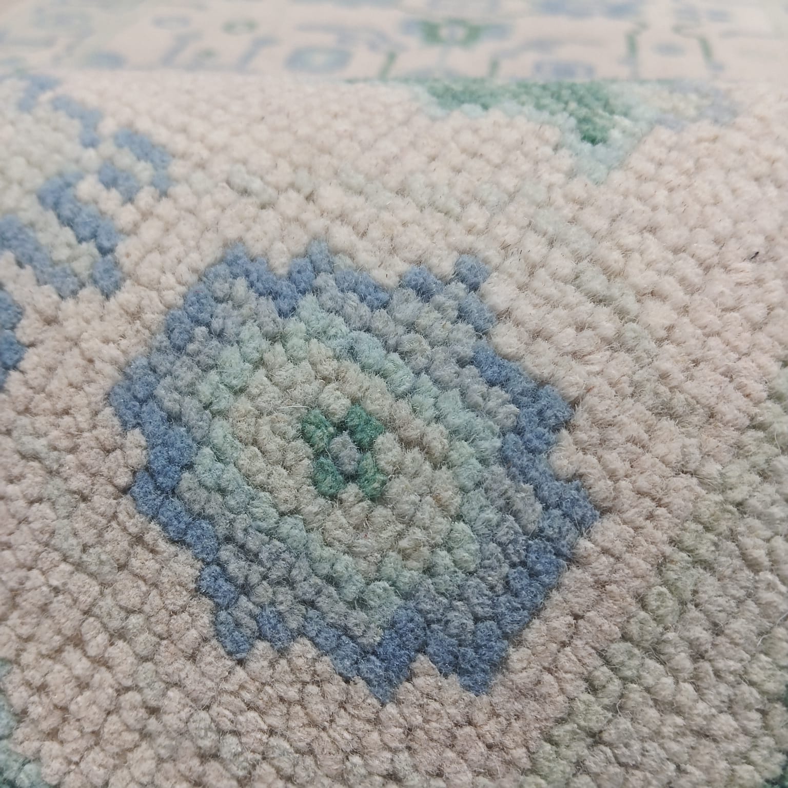 Close-up texture of blue and green tribal pattern handwoven wool rug