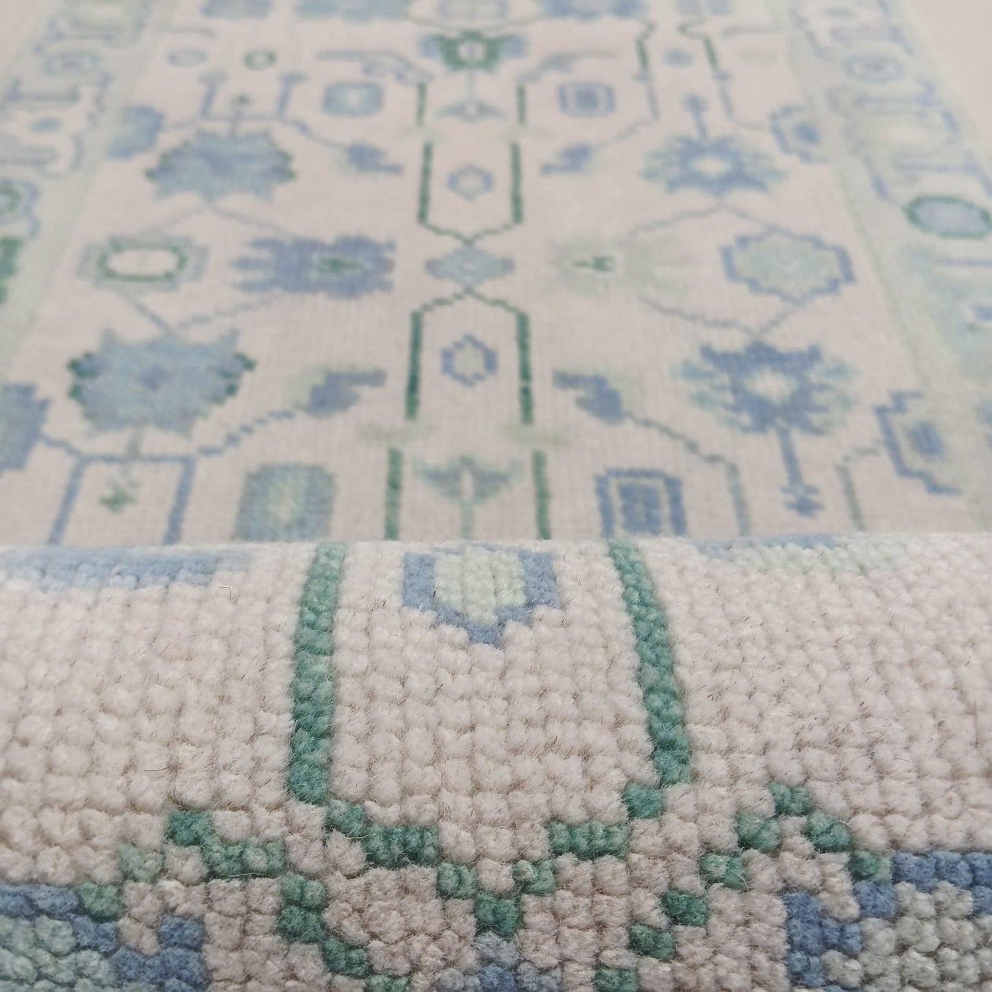 Close-up texture of blue and green tribal pattern handwoven wool rug