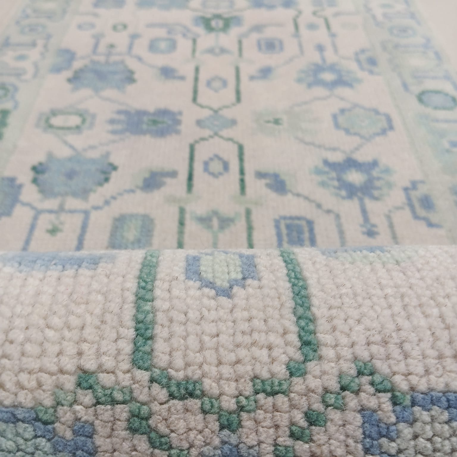 Close-up texture of blue and green tribal pattern handwoven wool rug