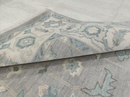Folded corner detail showing thickness and texture of blue grey hand tufted rug