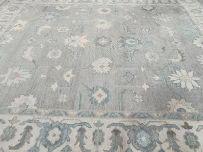 Center medallion detail of blue grey ivory Oushak style area rug