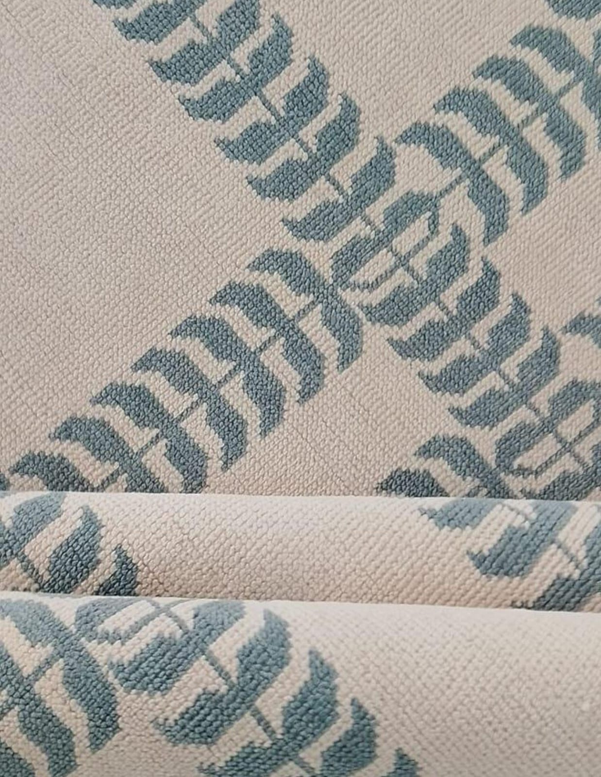 Close up of blue and ivory handwoven wool rug with modern geometric pattern and flatweave texture