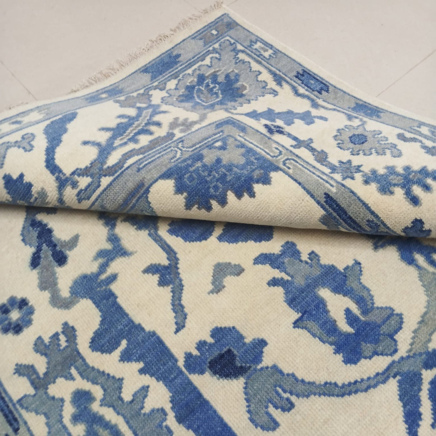 Border design detail of blue and ivory Oushak wool rug
