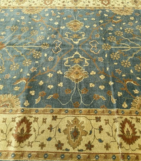 Handmade Blue Oushak Rug featuring traditional floral motifs, ivory border, and premium wool craftsmanship
