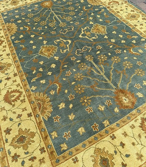 Handmade Blue Oushak Rug featuring traditional floral motifs, ivory border, and premium wool craftsmanship