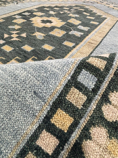 Folded corner of handmade blue Oushak wool rug showing medium pile, dense weave, and premium handcrafted construction