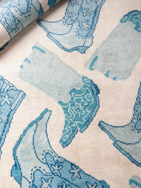 Close-up of blue and teal bird motif with textured woven rug surface