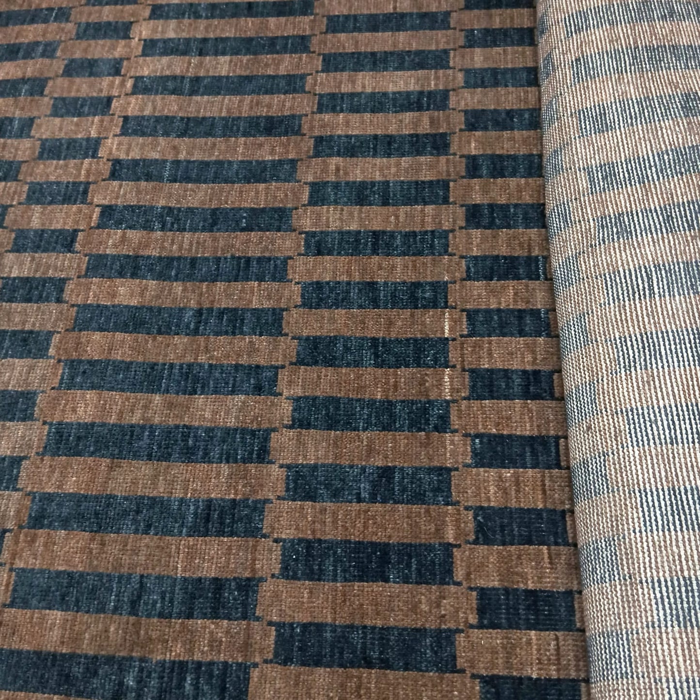 Full view of brown and black handwoven striped wool rug
