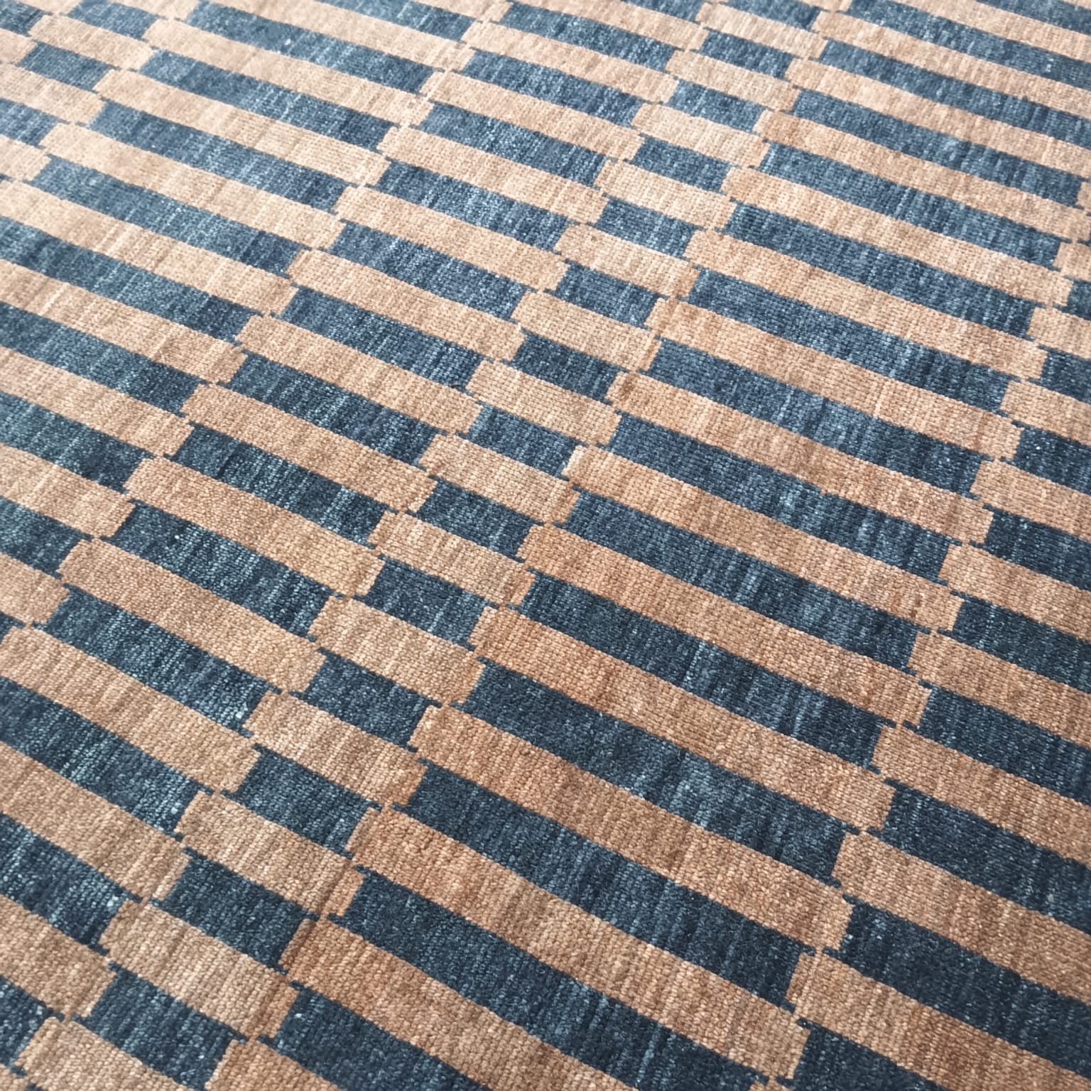 Striped pattern detail on brown and black handwoven wool rug
