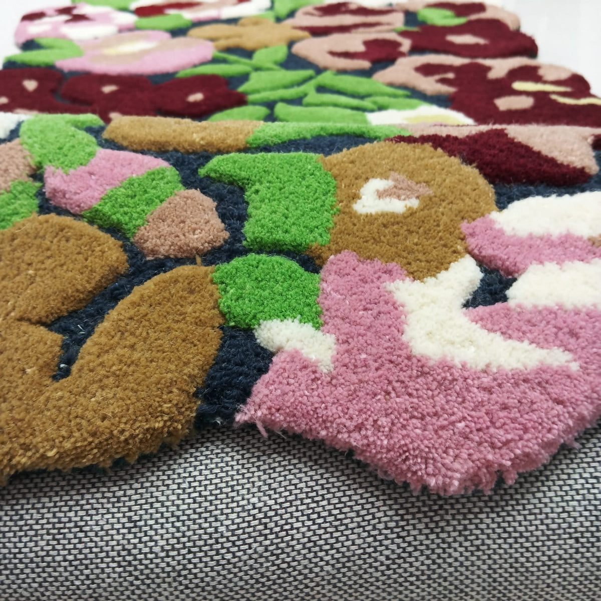 Burgundy pink green and cream floral pattern on a colorful area rug