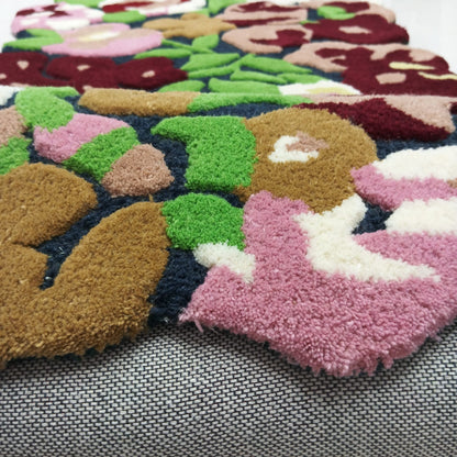 Burgundy pink green and cream floral pattern on a colorful area rug