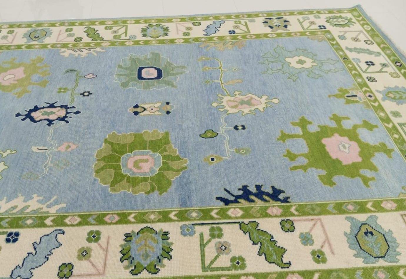 Classic Oushak flatweave wool rug featuring floral motifs on a pastel blue field