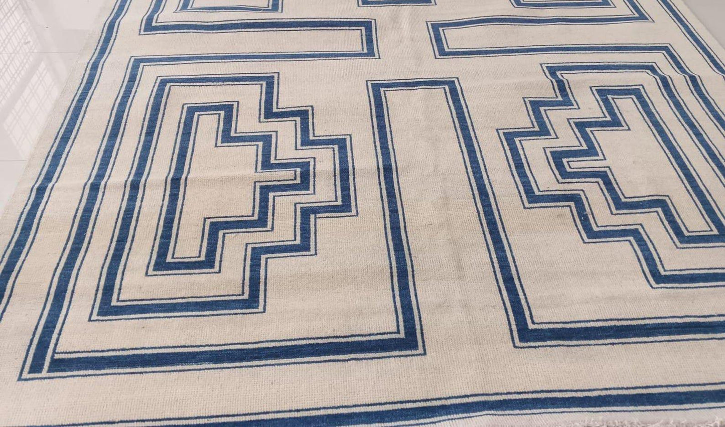 Angled view of contemporary geometric wool rug with low-profile flatweave texture