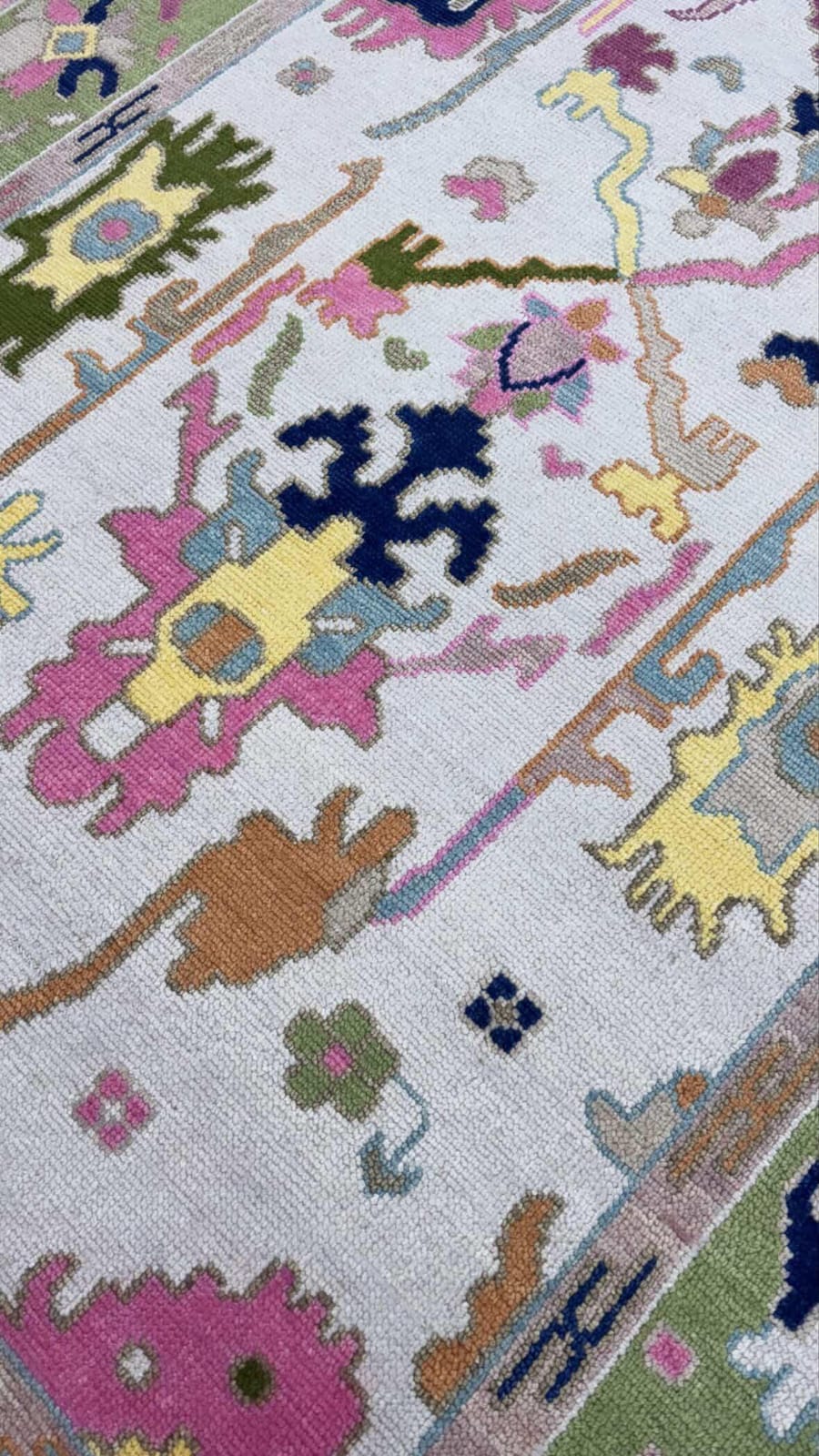 Vintage inspired pastel floral area rug with green border and colorful abstract motifs