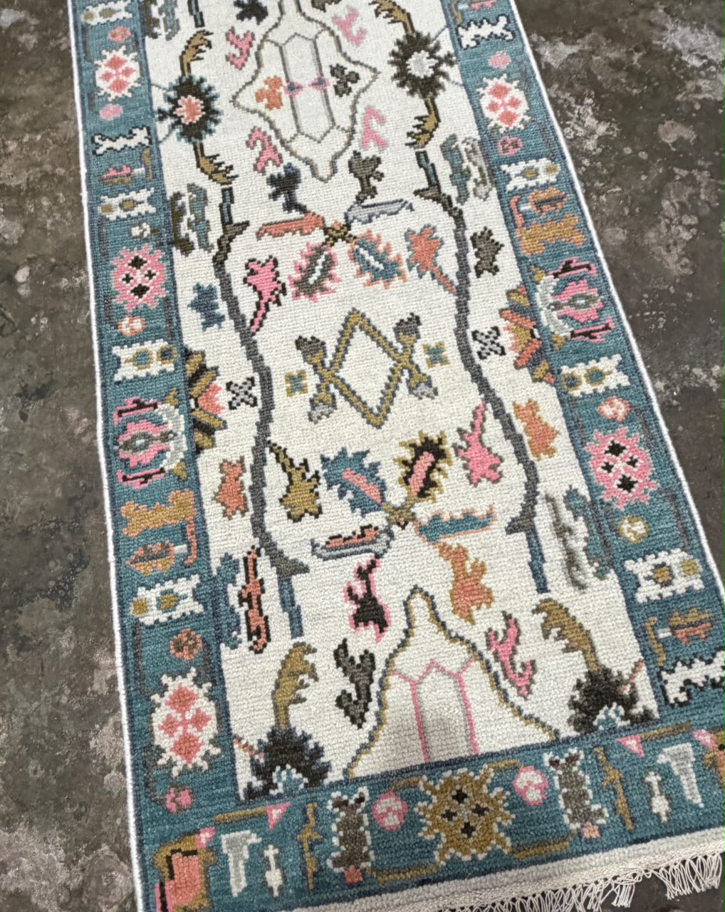 Textured surface of a cream floral runner rug with colorful raised-looking pattern details.