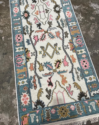 Textured surface of a cream floral runner rug with colorful raised-looking pattern details.