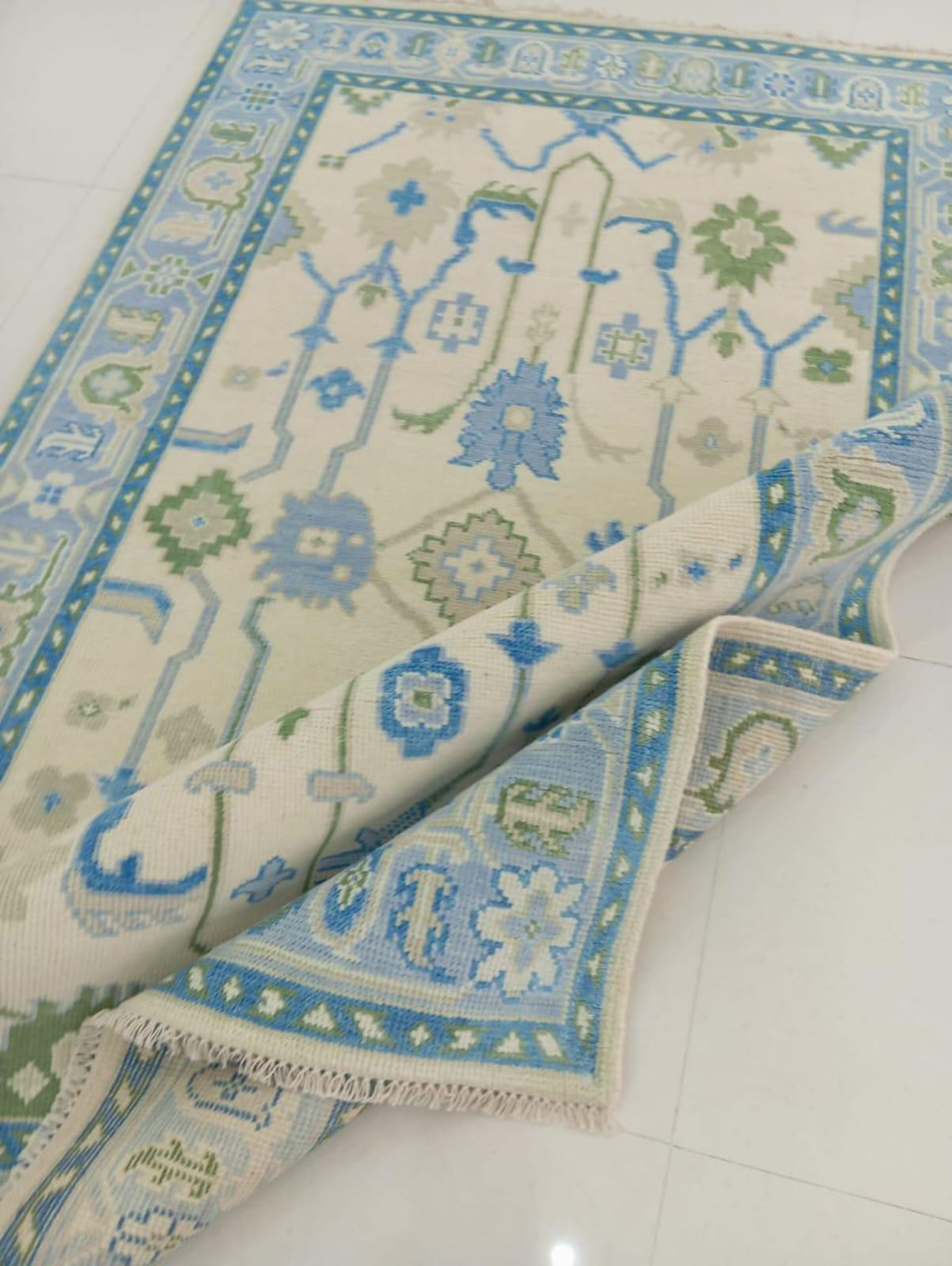 Folded Oushak wool rug highlighting low-profile flatweave structure