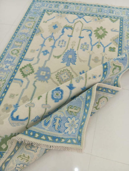 Folded Oushak wool rug highlighting low-profile flatweave structure