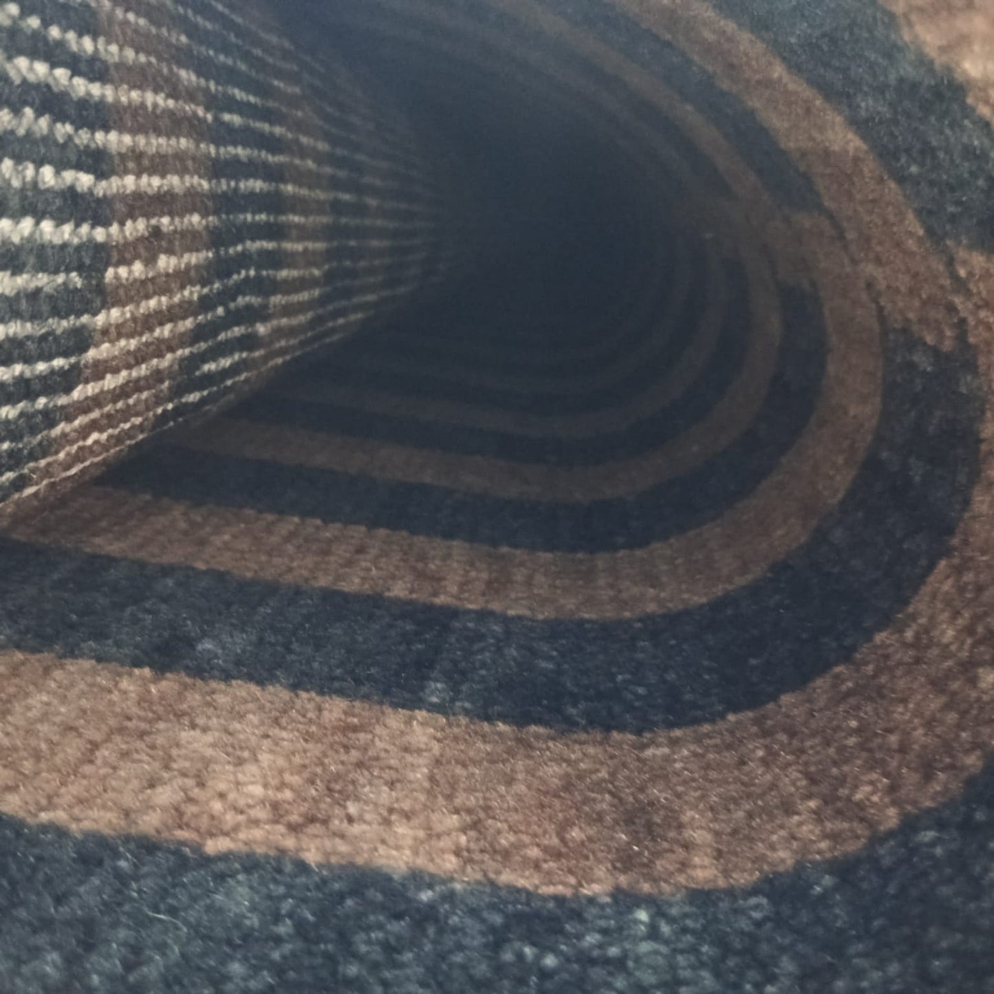 Flatwoven back detail of brown and black handwoven wool rug
