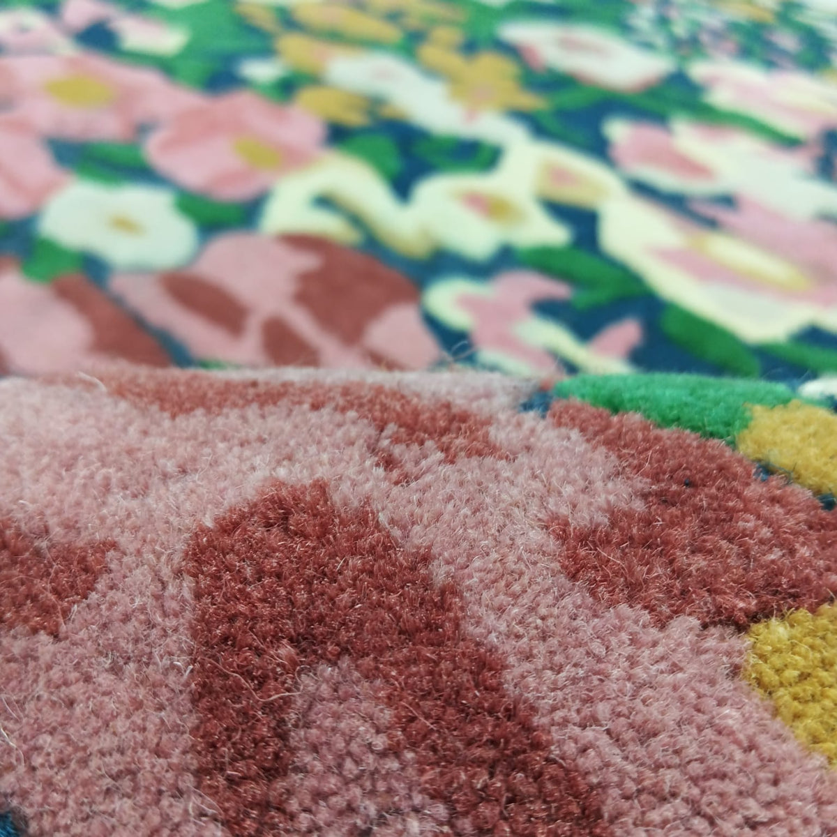 Backing detail of a colorful tufted floral area rug