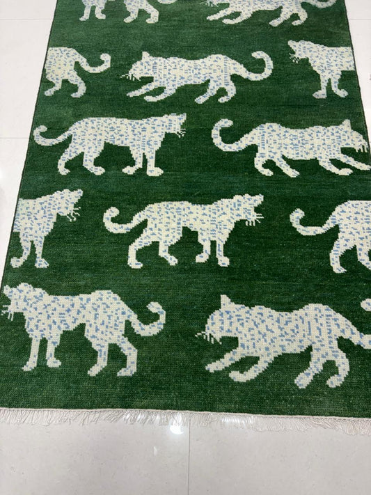 Detail of leopard pattern on handwoven green wool rug

