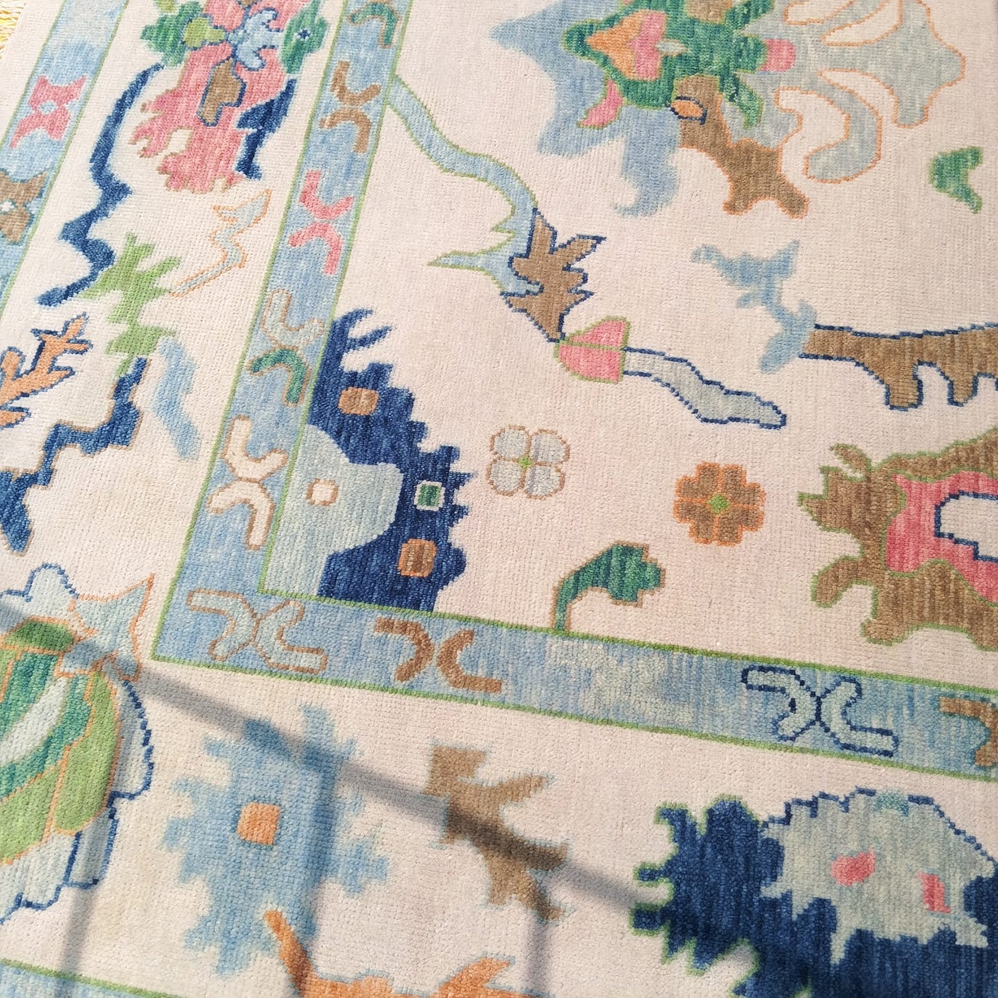 Folded corner of hand-knotted Oushak rug showing thickness and wool pile