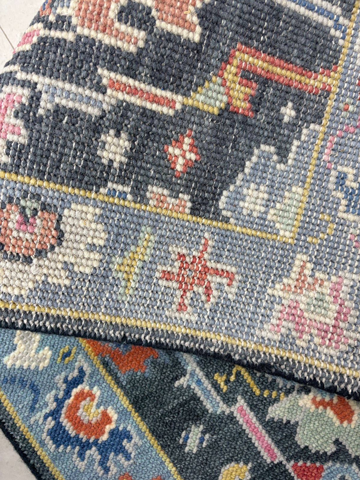 Close-up of hand-knotted Oushak rug showing dense wool texture and fine craftsmanship