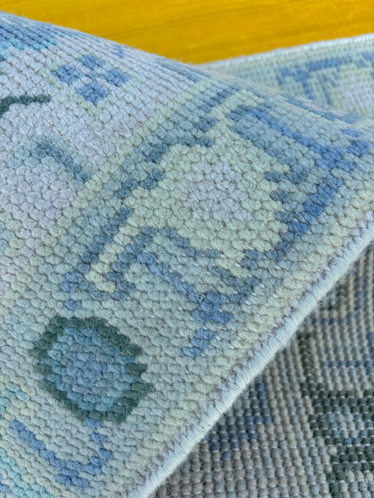 Detailed texture of hand-knotted Oushak rug made from natural wool