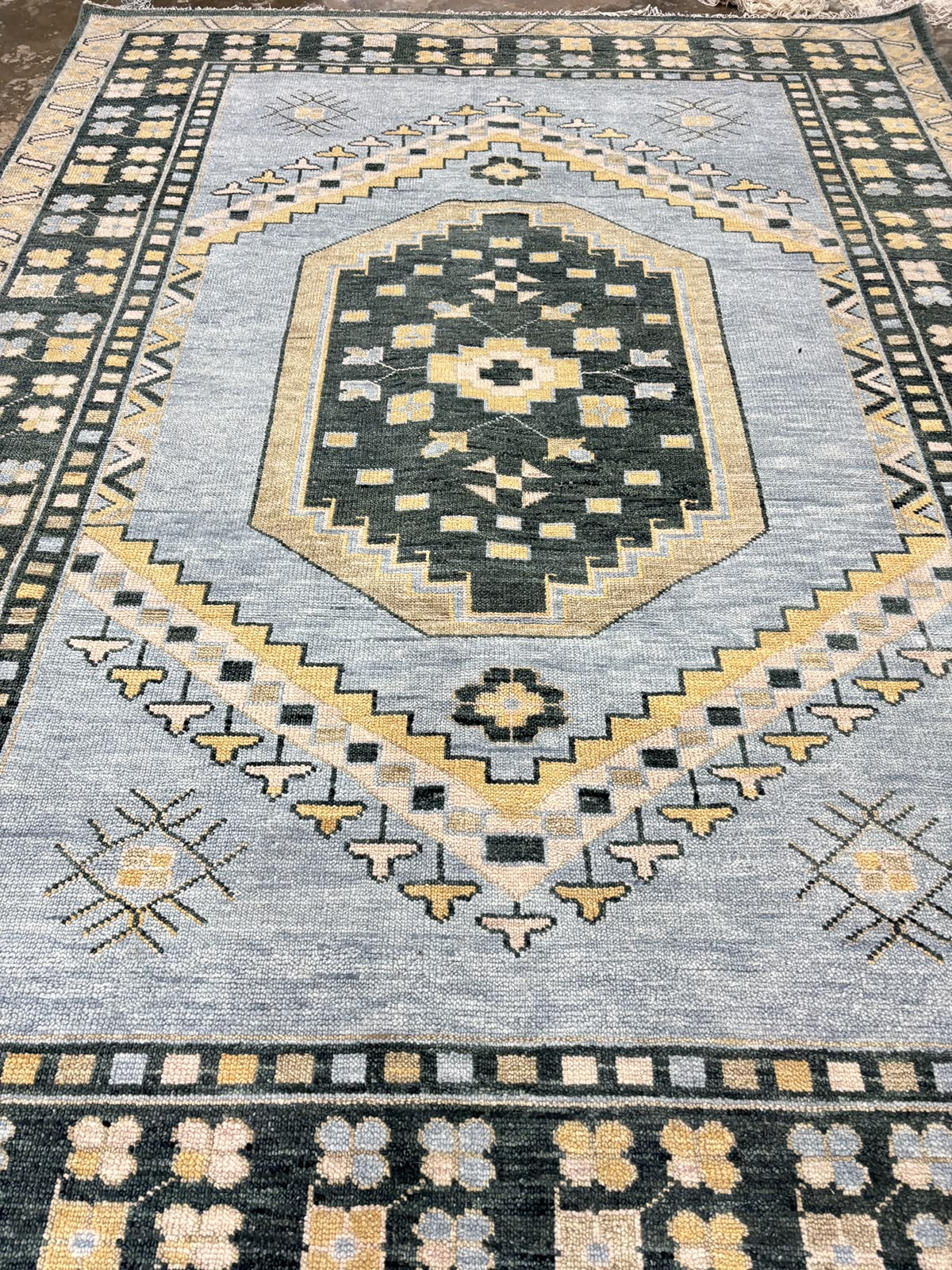 Handmade blue geometric Oushak wool area rug with traditional tribal medallion, charcoal border, and vintage Turkish-inspired design.