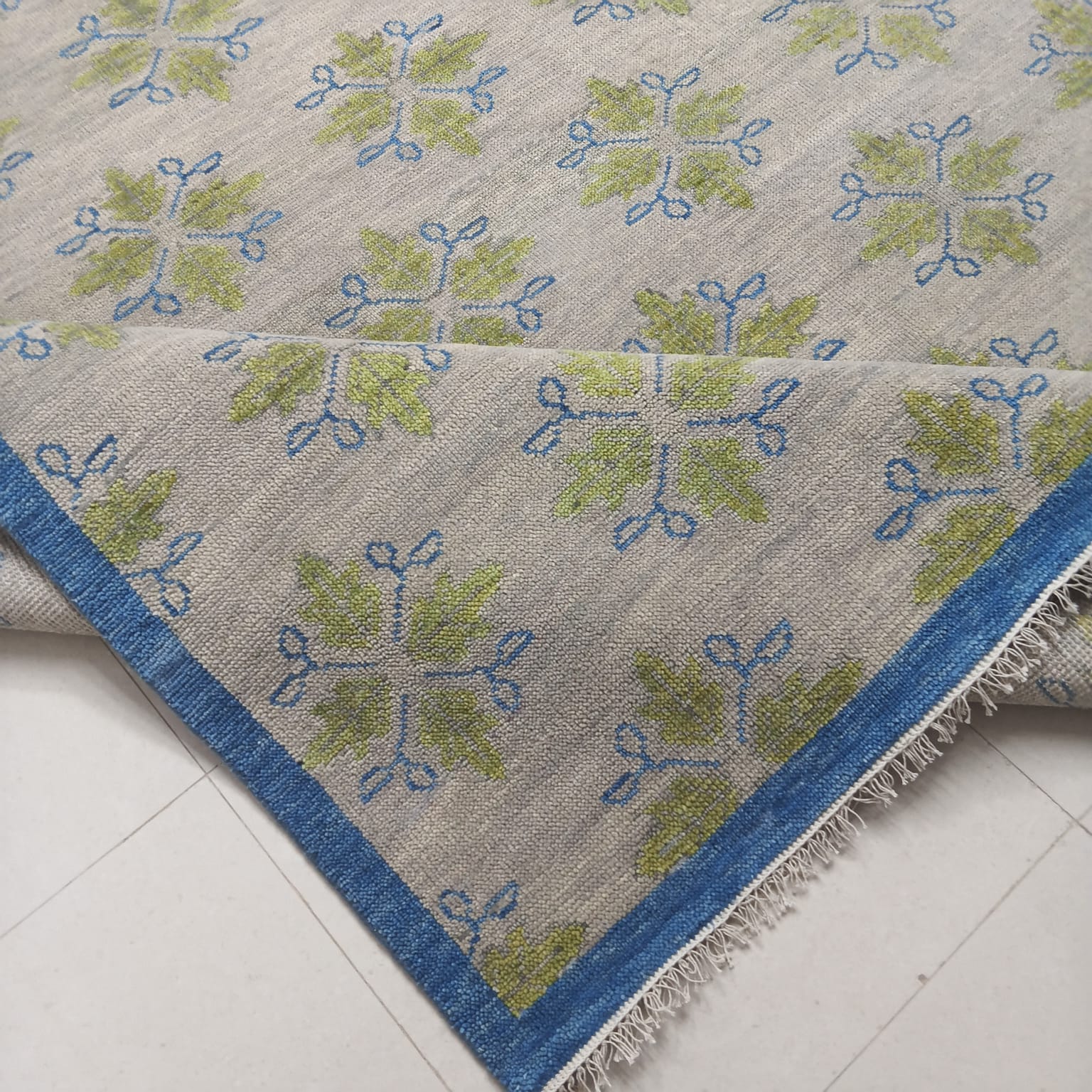 Folded handmade flatweave wool rug showing craftsmanship and low-pile construction
