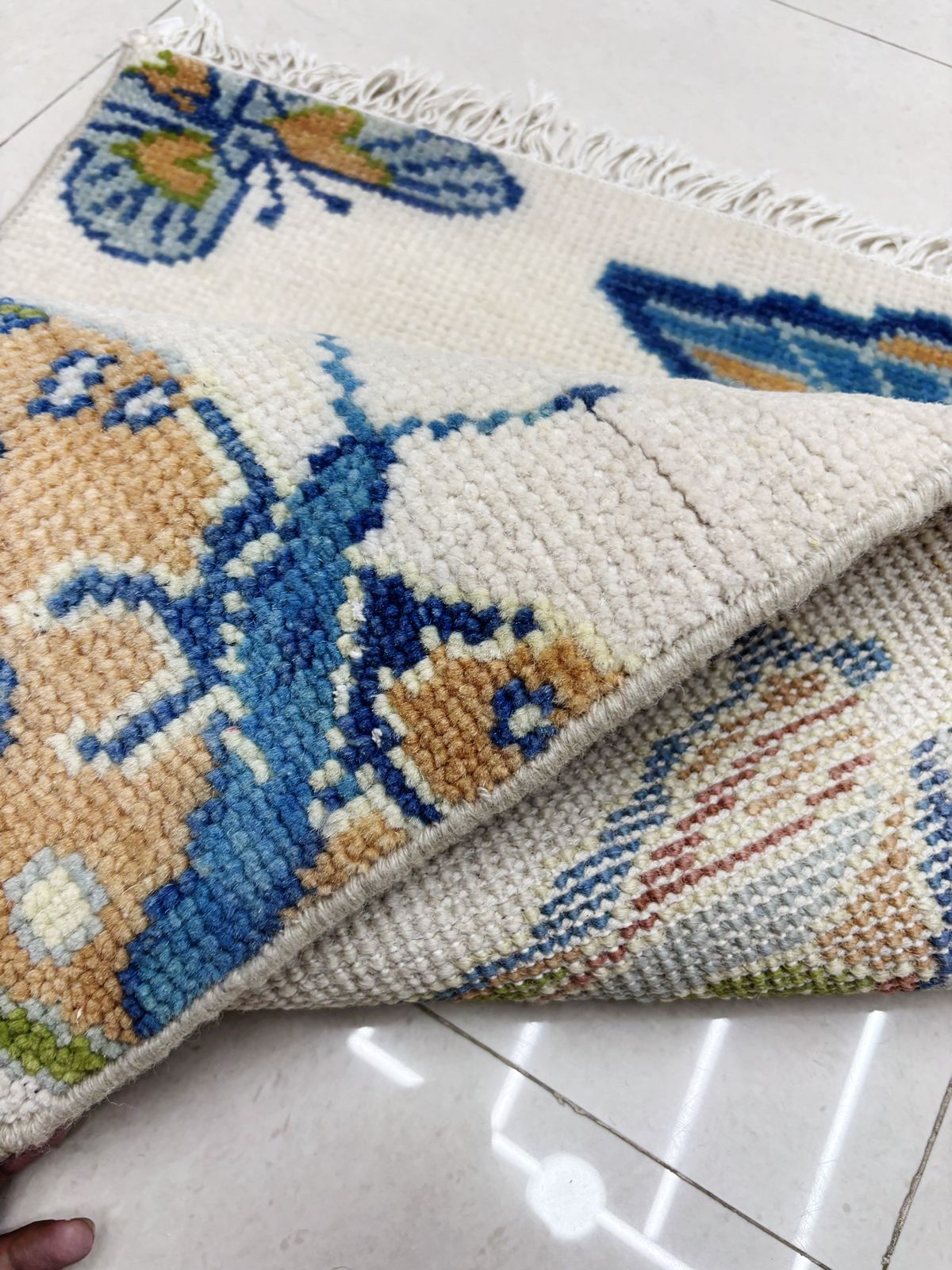 Folded handmade butterfly rug showing artisan craftsmanship and construction