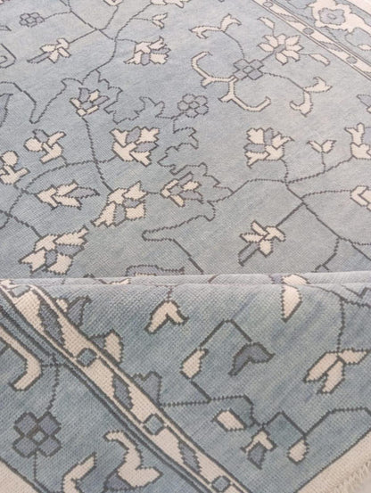 Handmade light blue wool area rug with floral pattern