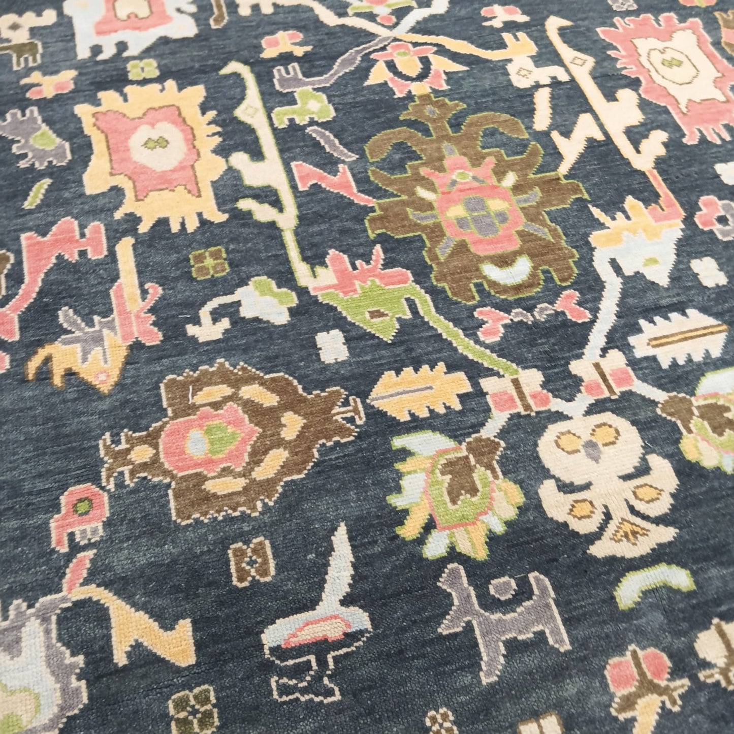 Handmade navy blue Oushak rug with tribal motifs and wool pile