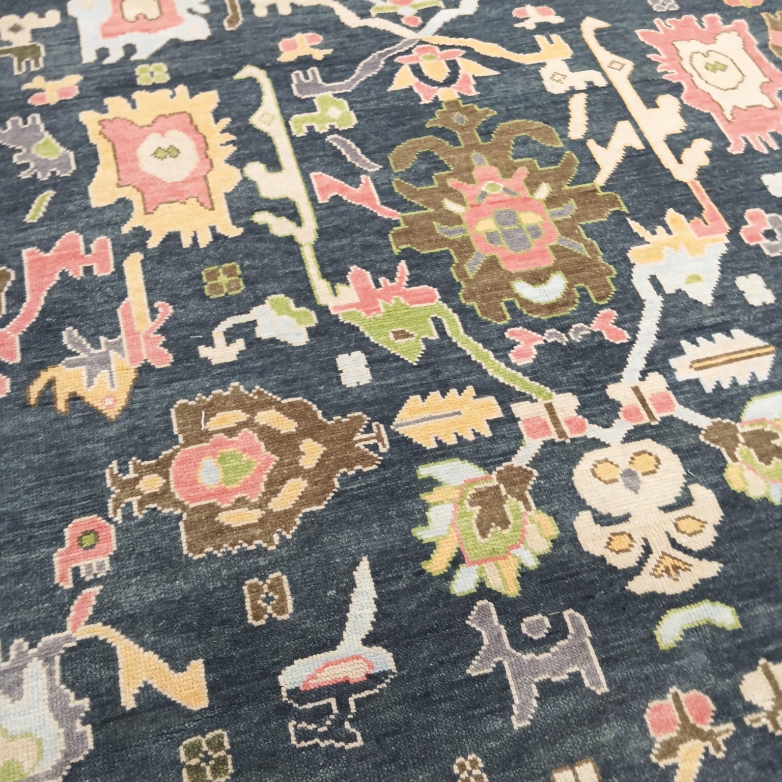 Handmade navy blue Oushak rug with tribal motifs and wool pile